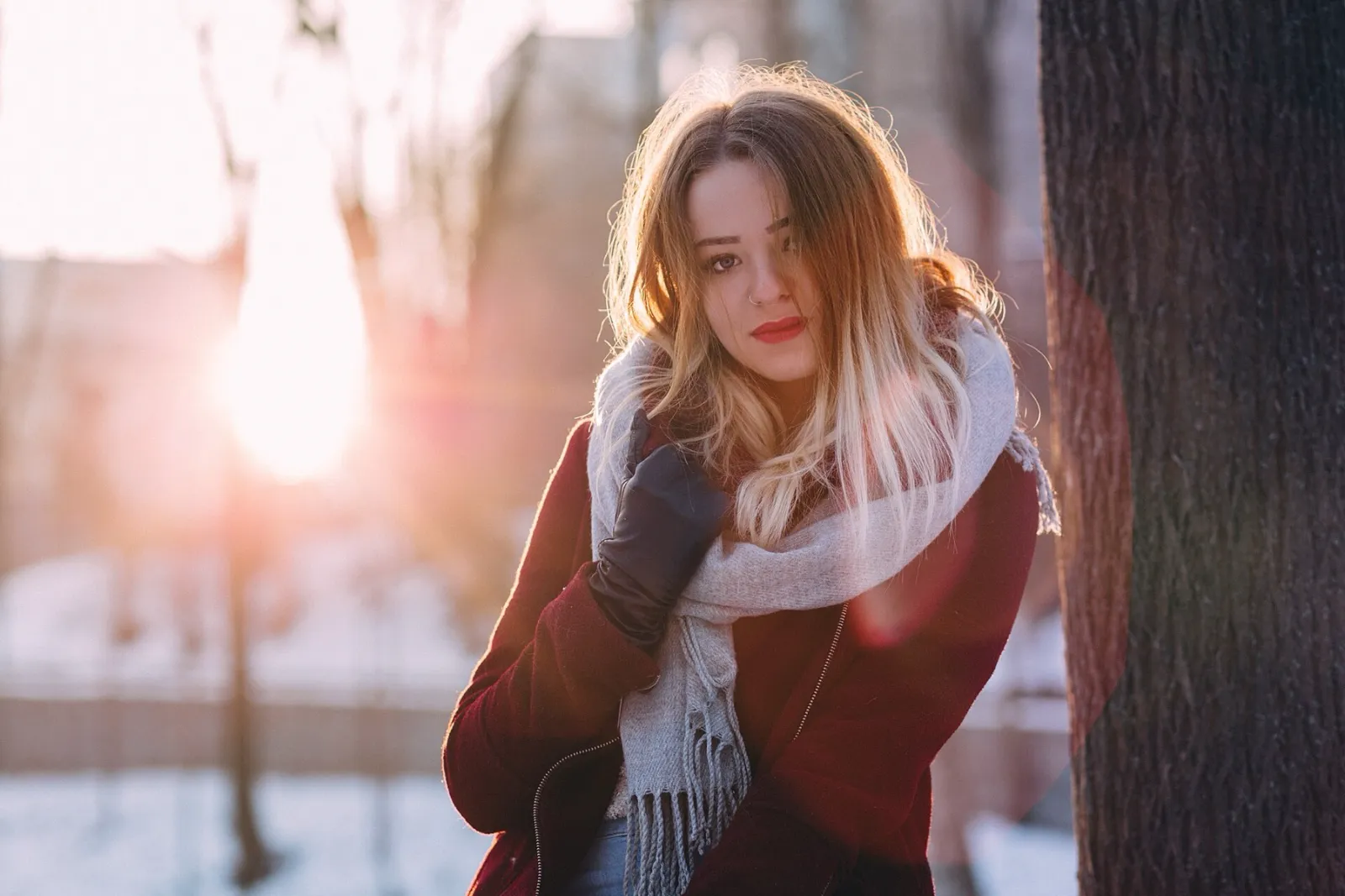 Moça com um cachecol branco de tricô numa tarde de inverno