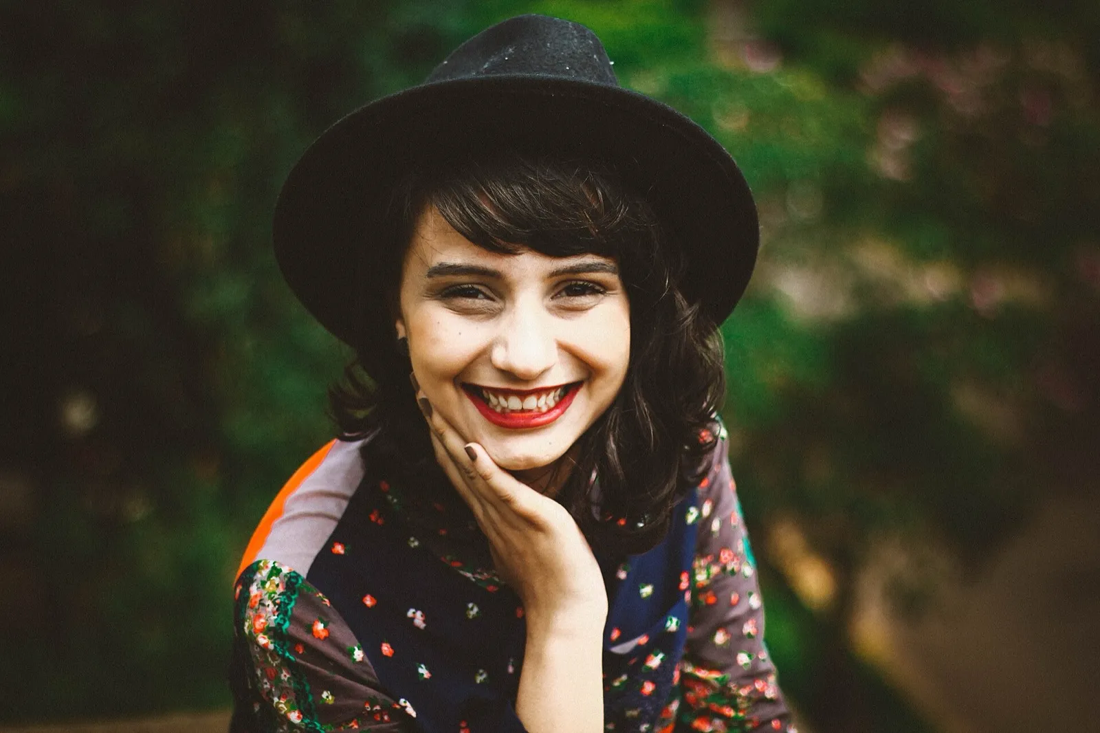 Mulher sorrindo com a mão no rosto
